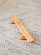 Handcrafted wooden Shena push-up board on a carpet