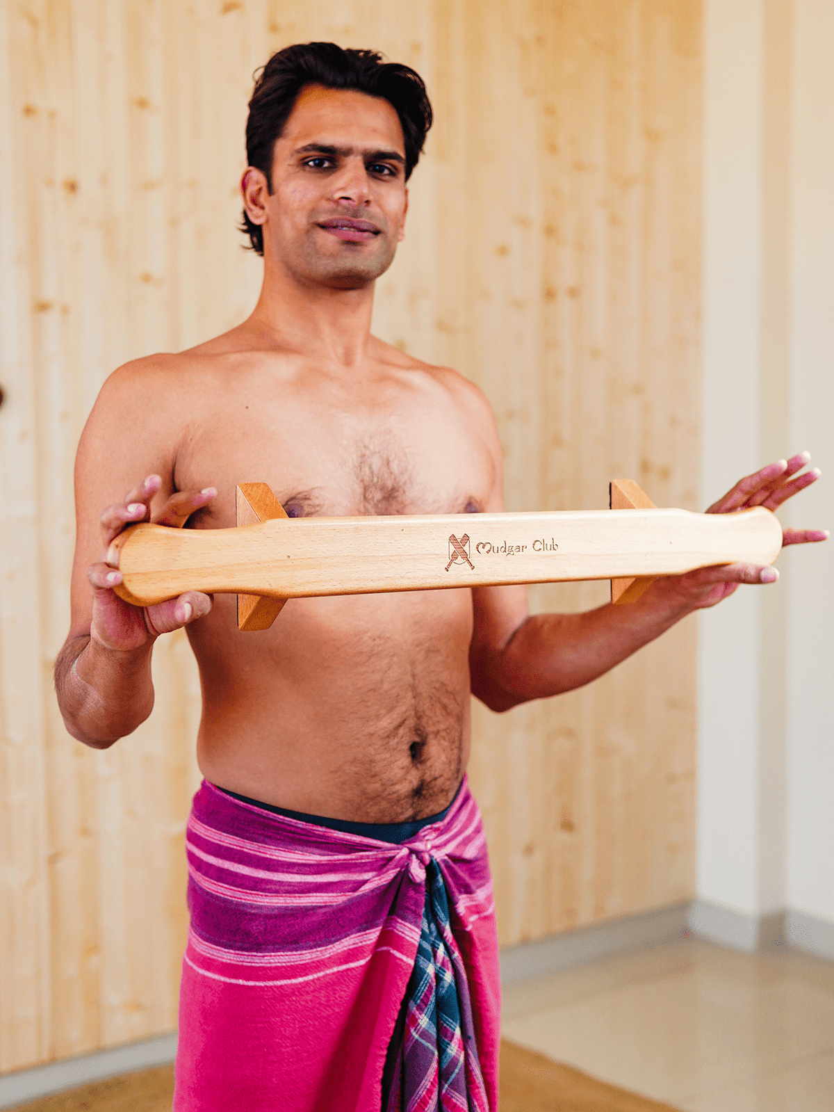Anjit holding the handcrafted wooden Shena push-up board